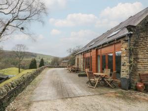 a stone cottage with a table and chairs outside at Cragg Hall View in Mytholmroyd