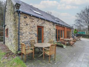 a brick building with a table and chairs in front of it at Cragg Hall View in Mytholmroyd +15 photos