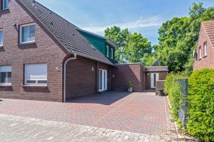a brick house with a brick driveway at Ferienwohnung Bel Air in Bensersiel