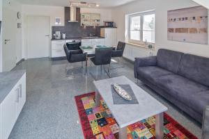 a living room with a couch and a table at Ferienwohnung Bel Air in Bensersiel