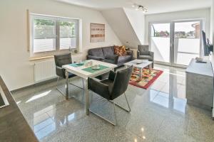 a living room with a table and a couch at Ferienwohnung Bel Air in Bensersiel