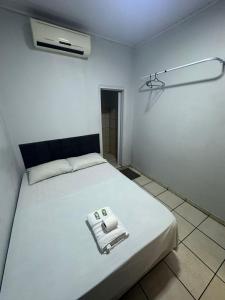 a white room with a bed with a towel on it at Hotel São Cristóvão in Marabá
