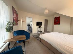 a bedroom with a bed and a table and a tv at The Loft Ashley Road in Poole