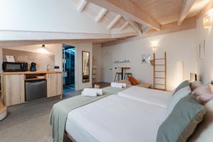a bedroom with a large white bed and a kitchen at Sandoñana Old Palace Lodge in Villafufre