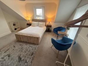 a bedroom with a bed and a blue chair at The Loft Ashley Road in Poole