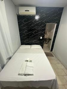 a bedroom with a bed with a towel on it at Hotel São Cristóvão in Marabá