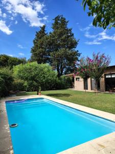 a blue swimming pool in a yard with trees at Los jazmines de Duggan in Duggan +15 photos