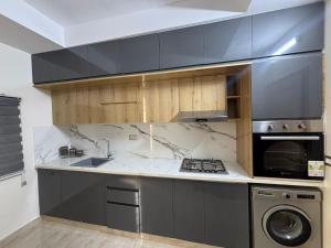 a kitchen with gray cabinets and a stove top oven at Dar Lina in Tozeur