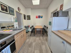 a kitchen with a refrigerator and a table with chairs at Wohnung mit Balkon in Zwickau