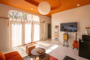 a living room with a large window and a tv at Nana pool villa Kanchanaburi in Ban Hua Hin