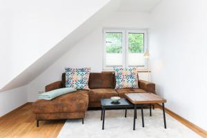 a living room with a brown couch and a table at Alte Molkerei in Esens