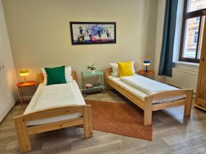 two twin beds in a room with two tables at Wohnung mit Balkon in Zwickau