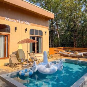a house with a swimming pool with an inflatable pool toy at Nana pool villa Kanchanaburi in Ban Hua Hin