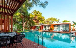 a swimming pool with chairs and a house at Club Marco Polo - Premium All Inclusive in Kemer