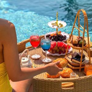 a woman sitting at a picnic table with food and drinks at Nana pool villa Kanchanaburi in Ban Hua Hin