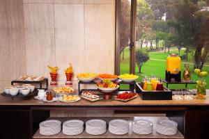 a buffet with plates and food on a table at NH Collection Bogota Hacienda Royal in Bogotá +28 photos