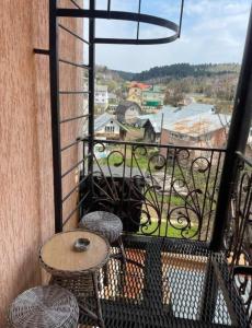 a balcony with a table and chairs and a view at Едем in Skhidnitsa