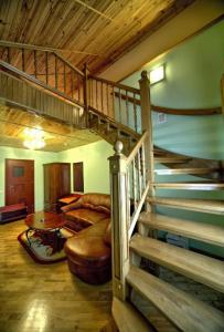 a living room with a spiral staircase in a house at Едем in Skhidnitsa