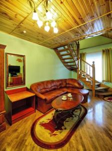 a living room with a leather couch and a table at Едем in Skhidnitsa