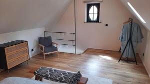 a living room with a chair and a dresser and a window at Gezellig huisje met zwembad en sauna in Ellezelles - Bellezelles in Ellezelles