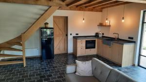 a kitchen with a black refrigerator and a staircase at Gezellig huisje met zwembad en sauna in Ellezelles - Bellezelles in Ellezelles