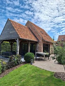 a gazebo with a picnic table in a yard at Gezellig huisje met zwembad en sauna in Ellezelles - Bellezelles in Ellezelles