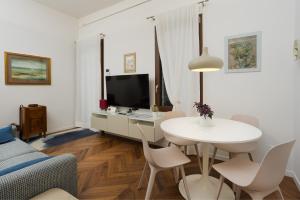 a living room with a white table and a tv at La Casa sui Colli in Bologna