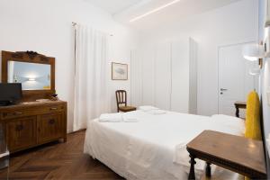 a white bedroom with a bed and a mirror at La Casa sui Colli in Bologna +15 photos