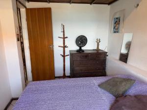a bedroom with a bed and a dresser with a clock at Santo Antônio Além do Carmo - apartamento com varanda e vista pro mar, até 3 pessoas in Salvador