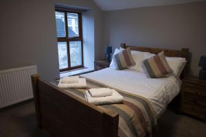 a bedroom with a bed with two towels on it at The Milestone in Sowerby Bridge