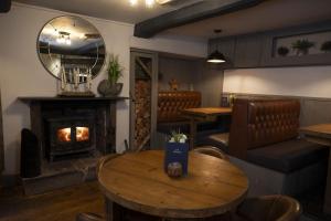 a restaurant with a fireplace and a table and chairs at The Milestone in Sowerby Bridge +6 photos