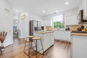 a kitchen with white cabinets and wooden floors at Meadow Park in Allen