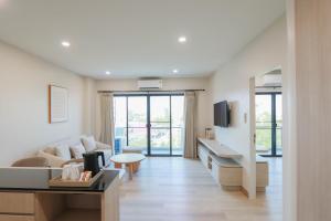 a living room with a couch and a table at Aster Canopy Suites & Living in Rayong