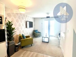 a living room with a yellow chair and blue chairs at Puffin House in Seaton Carew