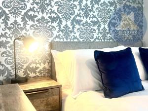 a bedroom with a bed with a blue and white wallpaper at Puffin House in Seaton Carew