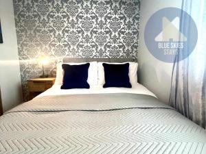 a bedroom with a white bed with blue pillows at Puffin House in Seaton Carew