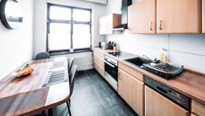 a kitchen with a table and a sink and a stove at Ferienwohnung Elb-Aue in Burg bei Magdeburg +13 photos