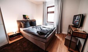 a small bedroom with a bed and a television at Ferienwohnung Elb-Aue in Burg bei Magdeburg