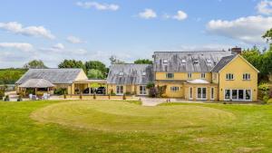 a large yellow house with a large yard at Broadridge Manor in West Worlington