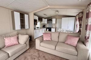 a living room with two couches and a kitchen at Sea View Platinum Caravan in Llanddulas