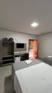 a bedroom with two beds and a flat screen tv at Mimari Hotel in Tangara da Serra