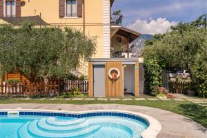 a swimming pool in a yard next to a house at Residence Villa degli Aranci in Riva del Garda