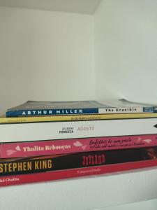 a stack of books sitting on top of a shelf at Mar à vista in São Luís