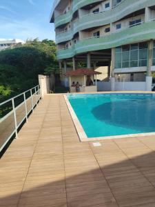 a boardwalk next to a swimming pool next to a building at Mar à vista in São Luís