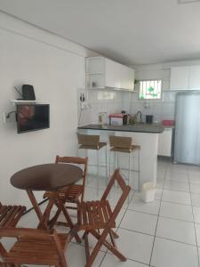 a kitchen with a table and chairs and a refrigerator at Mar à vista in São Luís
