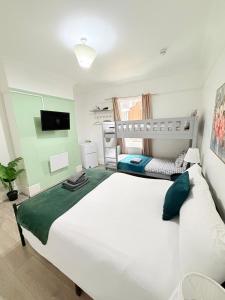 a bedroom with a large white bed and a tv at Wandsworth Guest Rooms 64 in London
