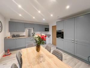 a kitchen with a table with a vase of flowers on it at Eriska View in Port Appin