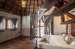ein Schlafzimmer mit einem Bett und einem großen Fenster in der Unterkunft Eco Cabañas Laak in Holbox