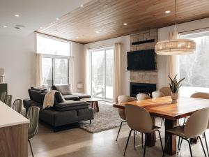 a living room with a table and a dining room at Chalet Gratitude with Private SPA & Sauna in Saint Come +35 photos