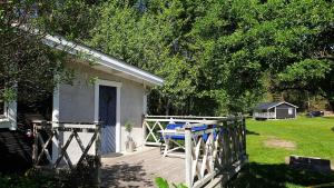 a white house with a porch and a fence at Björklunda, lakes, canoe, sauna in Näfstorp +20 photos